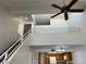 View of the staircase, second-floor balcony, ceiling fan and kitchen at 8940 Clairton Ct, Las Vegas, NV 89117
