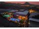 Twilight aerial view shows a modern home backyard with a pool, spa, and mountain views at 9 Reverie Heights Ave, Henderson, NV 89011
