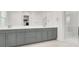 Bright bathroom with double vanity featuring gray cabinets, white countertops, and a glass-enclosed shower at 9 Reverie Heights Ave, Henderson, NV 89011