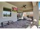 Cozy covered patio with outdoor seating, ceiling fan, and a mounted television for outdoor entertainment at 9 Reverie Heights Ave, Henderson, NV 89011