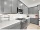 Kitchen features stainless steel appliances, quartz counters, gray cabinets and ample counter space for cooking at 9 Reverie Heights Ave, Henderson, NV 89011