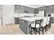 Beautiful kitchen with large quartz island with seating, gray cabinets, and stainless steel appliances at 9 Reverie Heights Ave, Henderson, NV 89011