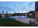 Backyard features a serene pool, spa, and turfed area overlooking the desert landscape at twilight at 9 Reverie Heights Ave, Henderson, NV 89011