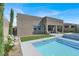 View of backyard pool and spa with turf, desert landscaping, and covered patio at 9 Reverie Heights Ave, Henderson, NV 89011
