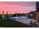 Tranquil backyard scene with illuminated pool, spa, turf, and desert views at twilight at 9 Reverie Heights Ave, Henderson, NV 89011