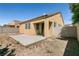 Home's rear exterior boasts a concrete patio, beige stucco, red tile roof, block wall, and desert landscaping at 9001 Picket Fence Ave, Las Vegas, NV 89143