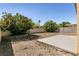 View of the home's backyard featuring desert landscaping, mature trees, and a concrete patio at 9001 Picket Fence Ave, Las Vegas, NV 89143