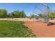 Well-maintained baseball field with lush green grass, surrounded by mature trees and open space at 9001 Picket Fence Ave, Las Vegas, NV 89143