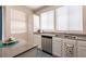 Bright kitchen with stainless steel dishwasher, granite countertops, and white cabinets at 9001 Picket Fence Ave, Las Vegas, NV 89143