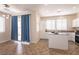 An open concept white kitchen with an island, stainless appliances, and tiled floors at 9001 Picket Fence Ave, Las Vegas, NV 89143