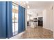 Bright kitchen with white cabinets, black appliances, tile floor, and sliding glass doors at 9001 Picket Fence Ave, Las Vegas, NV 89143