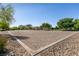 Sand volleyball court with net surrounded by decorative rocks, trees, and shrubs at 9001 Picket Fence Ave, Las Vegas, NV 89143
