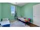 Cozy bedroom with two twin beds, green walls, and wood-look flooring at 9335 Tonkawa Ave, Las Vegas, NV 89178