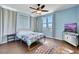Comfortable bedroom with light-blue walls, ceiling fan, floral bedding, and hard wood flooring at 9335 Tonkawa Ave, Las Vegas, NV 89178