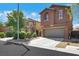 Two-story home with a two-car garage, desert landscaping, and a concrete driveway at 9335 Tonkawa Ave, Las Vegas, NV 89178