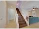 Staircase with white railings and wood steps, next to a living room with a teal couch at 9335 Tonkawa Ave, Las Vegas, NV 89178