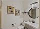 Cozy bathroom with a round mirror, stylish vanity, and framed art at 9421 Queen Charlotte Dr, Las Vegas, NV 89145