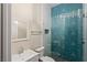 Modern bathroom with a geometric blue tile shower, white fixtures, and glass door at 9421 Queen Charlotte Dr, Las Vegas, NV 89145
