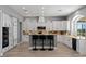 Bright kitchen featuring white cabinetry, an island with bar seating, stainless appliances, and a tile backsplash at 9421 Queen Charlotte Dr, Las Vegas, NV 89145