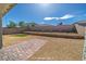 Spacious, low-maintenance backyard with gravel and brick-paved patio, enhanced by a retaining wall and lush green lawn at 9431 S Tee Pee Ln, Las Vegas, NV 89178
