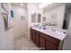 Bathroom with double sinks, tiled floors, framed mirrors, and ample counter space at 9431 S Tee Pee Ln, Las Vegas, NV 89178