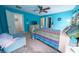 Spacious bedroom features blue walls, a ceiling fan, a queen sized bed, and a comfortable chair at 9431 S Tee Pee Ln, Las Vegas, NV 89178