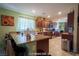 Well-lit, traditional style kitchen with dark wood cabinets, granite countertops, stainless steel appliances, and eat-in bar at 9431 S Tee Pee Ln, Las Vegas, NV 89178