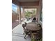 Covered back patio with seating, a table, desert landscaping, and a view of the backyard at 10023 Liberty View Rd, Las Vegas, NV 89148
