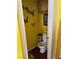 Compact bathroom featuring yellow walls with decorative butterfly decals and a classic white toilet at 10023 Liberty View Rd, Las Vegas, NV 89148