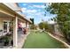 Inviting backyard with covered patio, lush artificial turf, and mature landscaping offers a private retreat at 10143 Canyon Hills Ave, Las Vegas, NV 89148