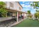 Beautiful backyard featuring a covered patio, lush turf, and vibrant flowering plants at 10143 Canyon Hills Ave, Las Vegas, NV 89148