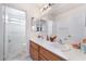 Bright bathroom featuring double sinks with wooden vanity at 10143 Canyon Hills Ave, Las Vegas, NV 89148