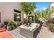 Private patio with comfortable seating surrounded by beautiful landscaping, bushes, and red roses at 10276 Cherry Brook St, Las Vegas, NV 89183