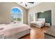 Bedroom featuring a large arched window, hardwood floors, and a mirrored sliding-door closet at 10276 Cherry Brook St, Las Vegas, NV 89183