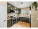 Well-equipped kitchen with stainless steel appliances, granite countertops, and stylish dark green cabinetry at 10276 Cherry Brook St, Las Vegas, NV 89183