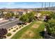 Neighborhood street featuring a grassy park, mature trees, well-kept lawns, and sidewalks, creating a serene environment at 10276 Cherry Brook St, Las Vegas, NV 89183