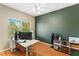 A well-lit office space featuring a large window, a modern ceiling fan, and hardwood flooring at 10276 Cherry Brook St, Las Vegas, NV 89183