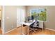 Office space with wood floors, bright window, modern desk, and white sliding-door closet at 10276 Cherry Brook St, Las Vegas, NV 89183