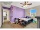This bedroom features a purple accent wall, decorated walls, a ceiling fan, and carpeted flooring at 10631 Kennedy Peak Ln, Las Vegas, NV 89166