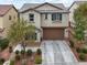 This two-story home features a well-manicured front yard, a two-car garage, and neutral colored paint at 10631 Kennedy Peak Ln, Las Vegas, NV 89166