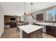 Open-concept kitchen with island seating, stainless appliances, and adjacent living area at 10631 Kennedy Peak Ln, Las Vegas, NV 89166