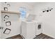 This laundry room features a modern washer and dryer, decor on the walls, and a window for natural light at 10631 Kennedy Peak Ln, Las Vegas, NV 89166