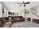 Open-concept living room leading to kitchen with a large sectional, area rug, and stair access at 10631 Kennedy Peak Ln, Las Vegas, NV 89166