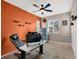Bright office space with orange accent wall, ceiling fan, and natural light at 10631 Kennedy Peak Ln, Las Vegas, NV 89166