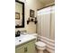 Bathroom featuring green vanity, sink, framed mirror, and neutral walls and fixtures at 1121 Majestic Canyon St, Henderson, NV 89052
