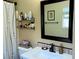 Bathroom with white sink, black hardware, and decorated with tile and floating shelves at 1121 Majestic Canyon St, Henderson, NV 89052