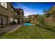 Backyard view showing the pool, lawn, patio, barbecue grill, and multi-story home at 11944 Dolcemente Ln, Las Vegas, NV 89138