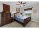 Comfortable bedroom with a wooden bed frame, dresser, and a window providing natural light, creating a cozy atmosphere at 11944 Dolcemente Ln, Las Vegas, NV 89138