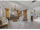 Elegant formal living room with tile flooring, decorative chandelier, and access to backyard pool at 11944 Dolcemente Ln, Las Vegas, NV 89138