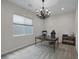 Bright office features a stylish chandelier, large window, and comfortable desk setup, perfect for a productive workspace at 11944 Dolcemente Ln, Las Vegas, NV 89138